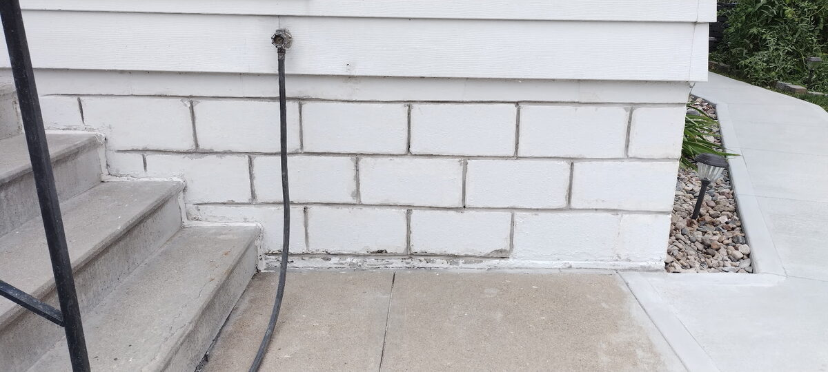Refinished and sealed block foundation wall beside front steps in Omaha