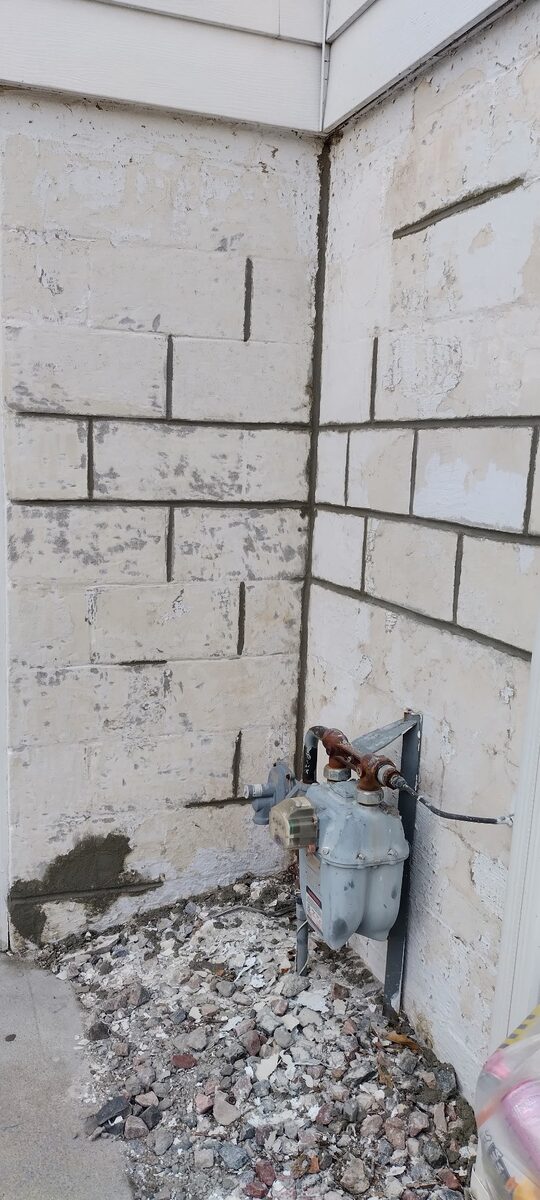 Spalled and damaged block foundation corner on an Omaha home before repair
