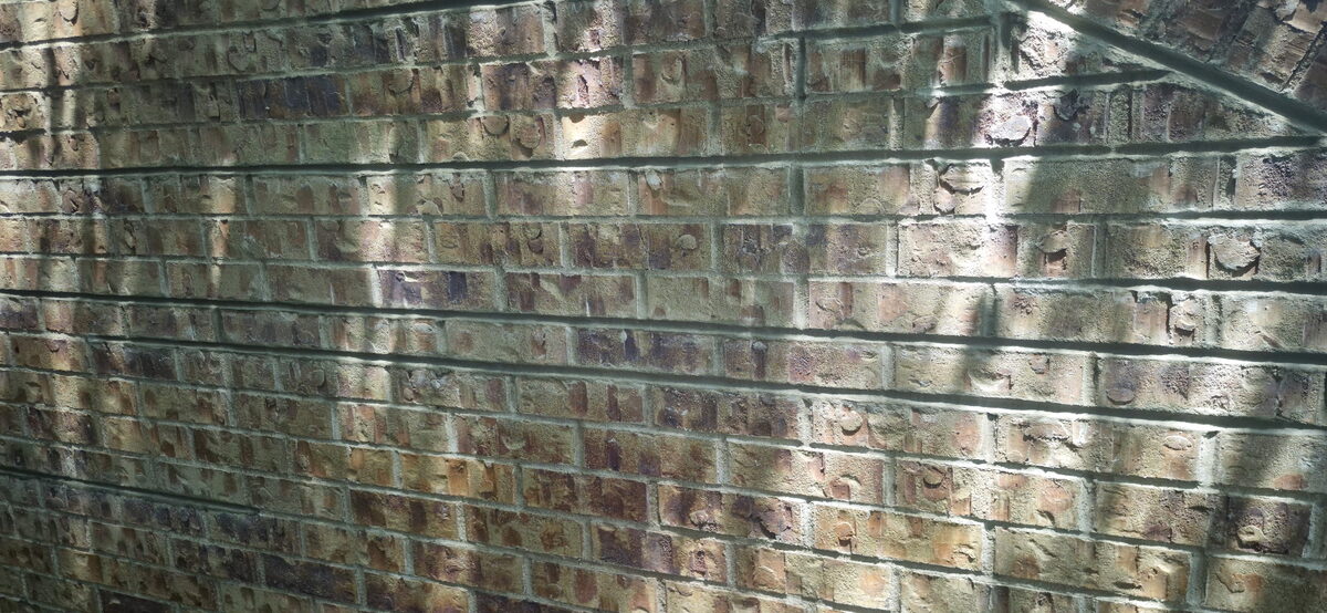 Antique glazed brick wall with repointed mortar joints in Omaha