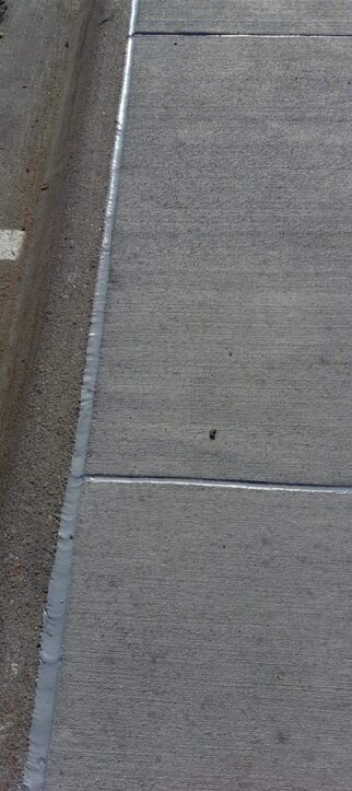 Long freshly caulked sidewalk expansion joint in Omaha