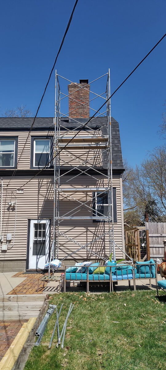 Scaffolding set up against a two-story Omaha home for a chimney rebuild