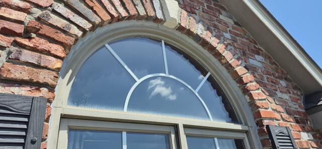 Arched brick window surround with restored mortar joints