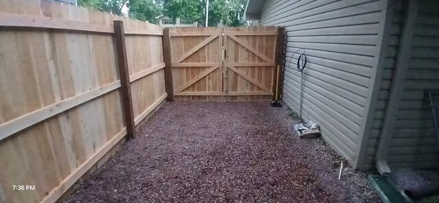 New wood privacy fence and gate installed along an Omaha home