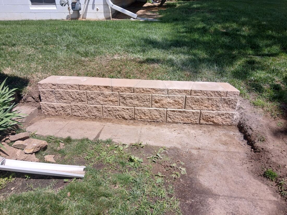 New block retaining wall with freshly regraded lawn in Omaha