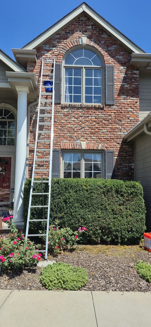 Crew ladder against a two-story brick Omaha home during brick repair