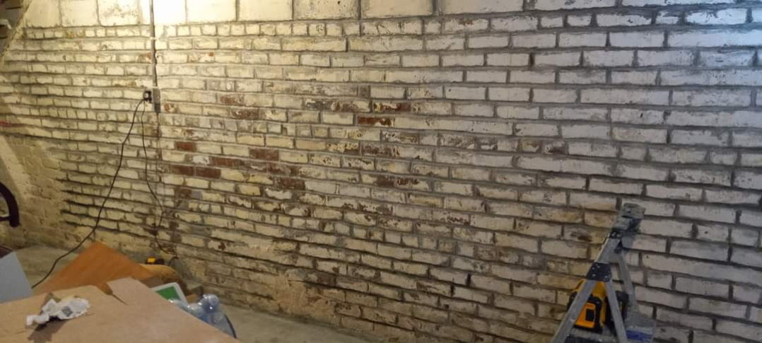 Moisture-stained basement brick wall in Omaha before waterproofing